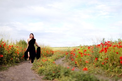 Photo of Smiling woman running in beautiful wildflower meadow