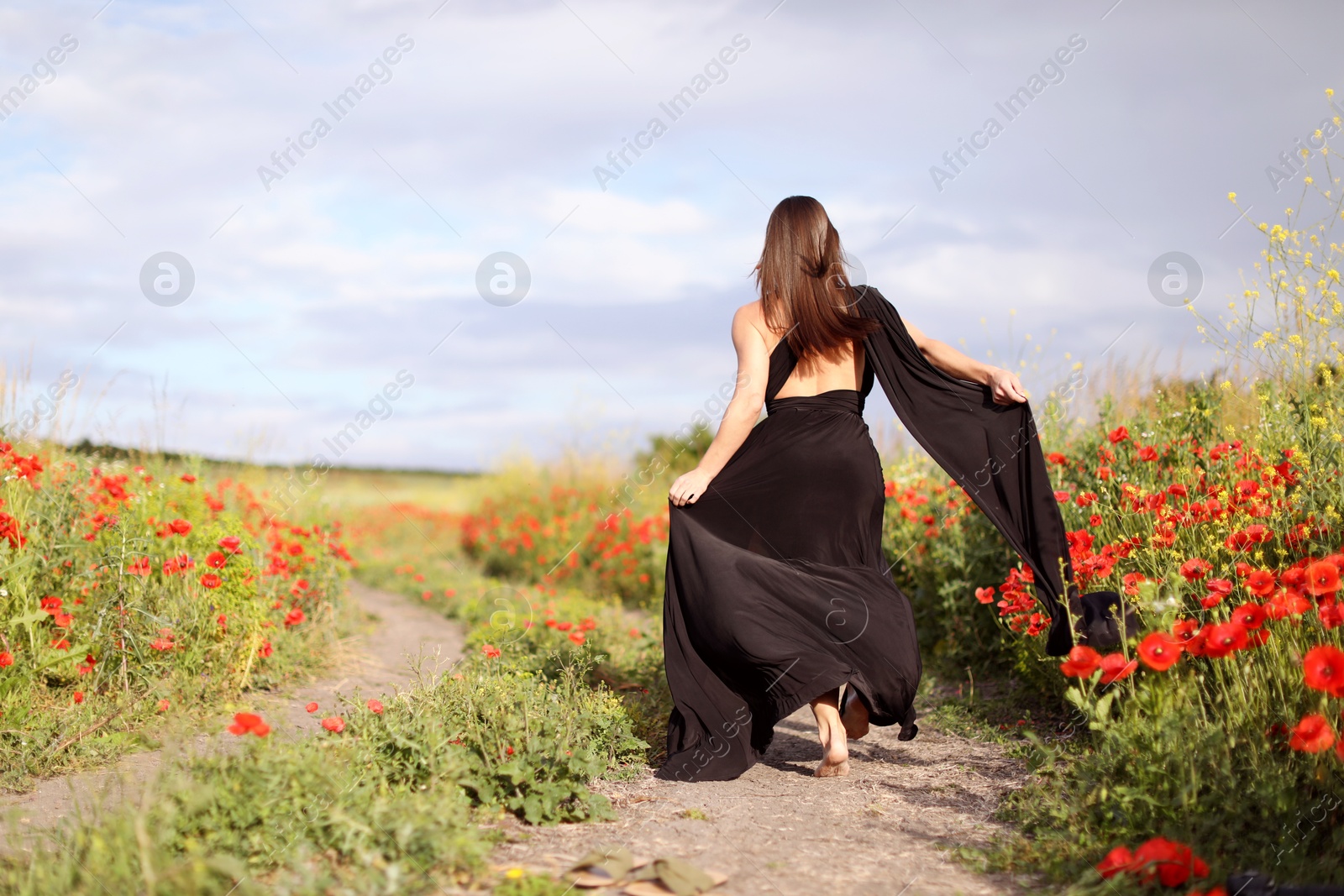 Woman running in morning wildflower meadow, back view Photo of Woman running in morning wildflower meadow, back view
