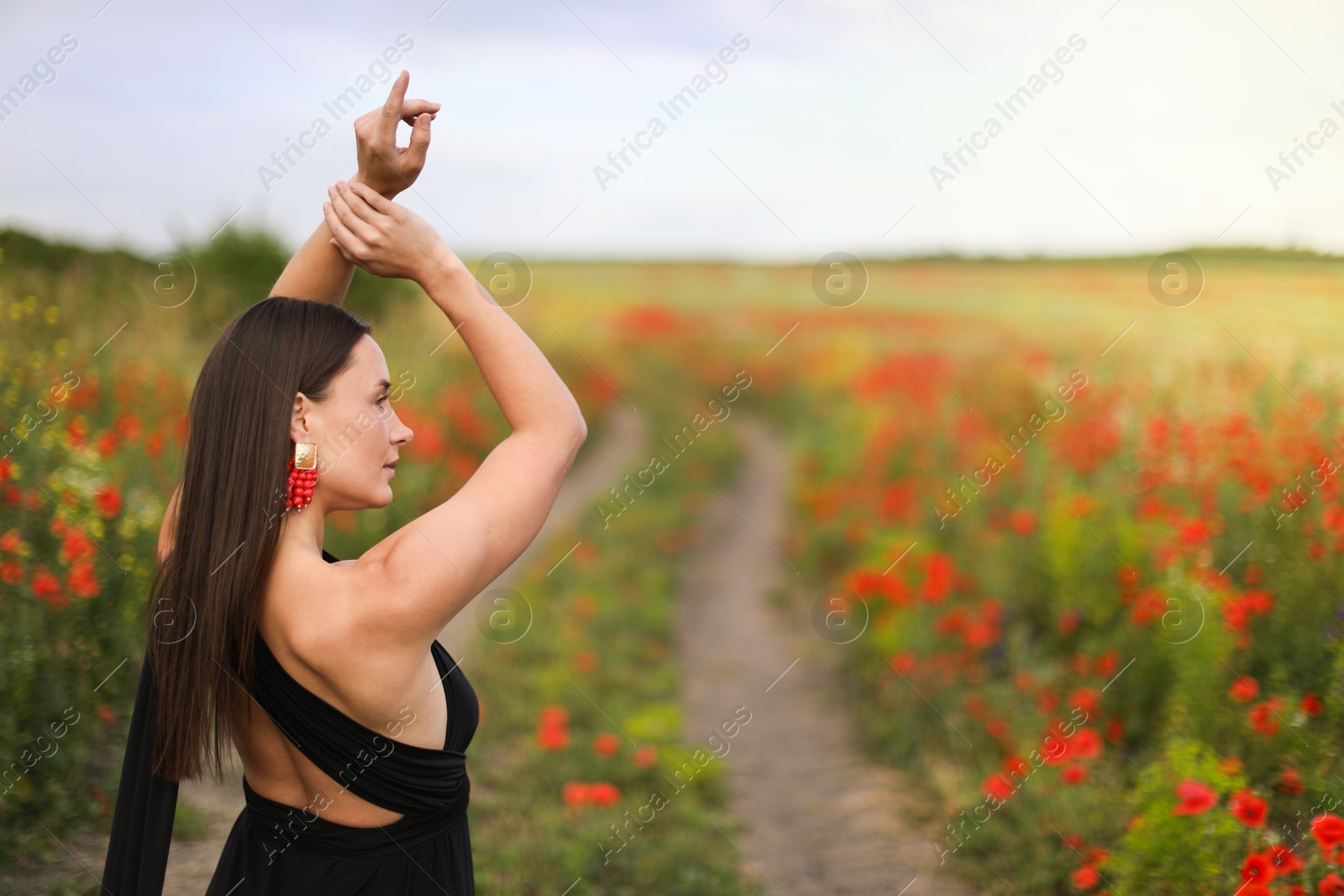 Beautiful woman posing in wildflower meadow. Space for text Photo of Beautiful woman posing in wildflower meadow. Space for text