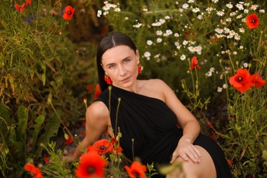 Photo of Portrait of beautiful woman among wildflowers in meadow