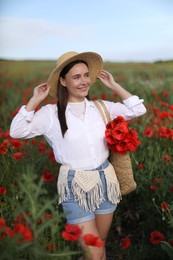 Photo of Smiling woman in hat with bag of poppy flowers in wildflower meadow