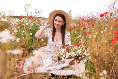 Photo of Smiling woman in hat posing in wildflower meadow