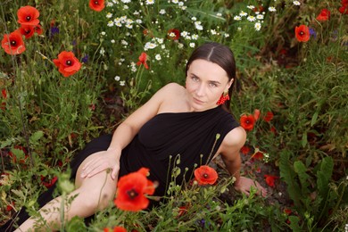 Photo of Beautiful woman posing among wildflowers in meadow