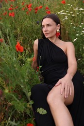 Photo of Beautiful woman posing among wildflowers in meadow