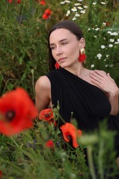Photo of Beautiful woman posing among wildflowers in meadow