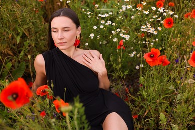 Photo of Beautiful woman posing among wildflowers in meadow