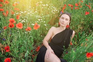 Photo of Beautiful woman posing among wildflowers in morning meadow