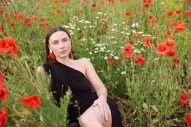 Photo of Beautiful woman posing among wildflowers in meadow