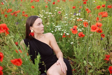 Photo of Beautiful woman posing among wildflowers in meadow