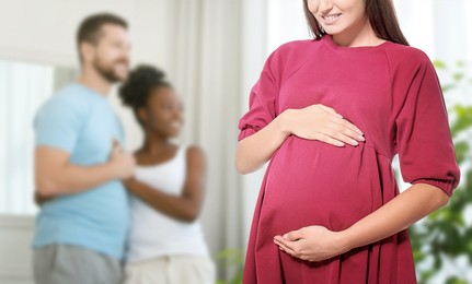 Image of Surrogate mother and intended parents indoors, selective focus