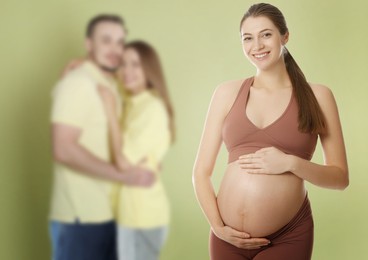 Image of Surrogate mother and intended parents against olive color background, selective focus