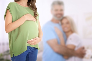 Image of Surrogate mother and intended parents indoors, selective focus