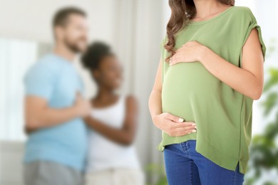 Image of Surrogate mother and intended parents indoors, selective focus