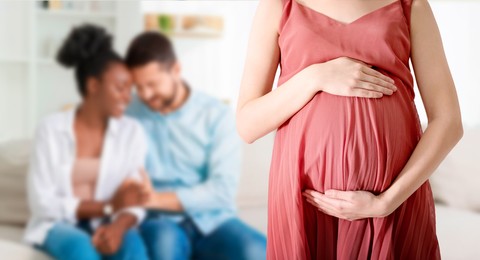 Image of Surrogate mother and intended parents indoors, selective focus