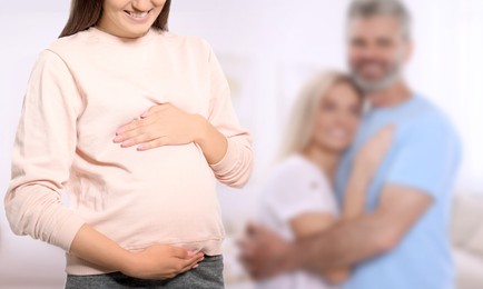 Image of Surrogate mother and intended parents indoors, selective focus