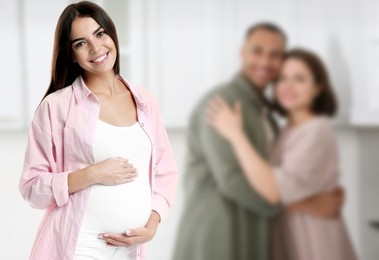 Image of Surrogate mother and intended parents indoors, selective focus
