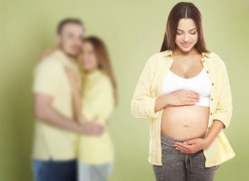 Image of Surrogate mother and intended parents against olive color background, selective focus
