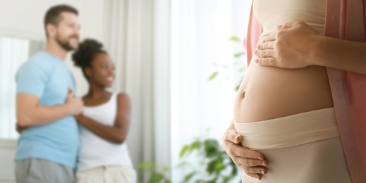 Image of Surrogate mother and intended parents indoors, selective focus