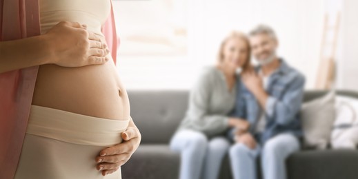 Image of Surrogate mother and intended parents indoors, selective focus