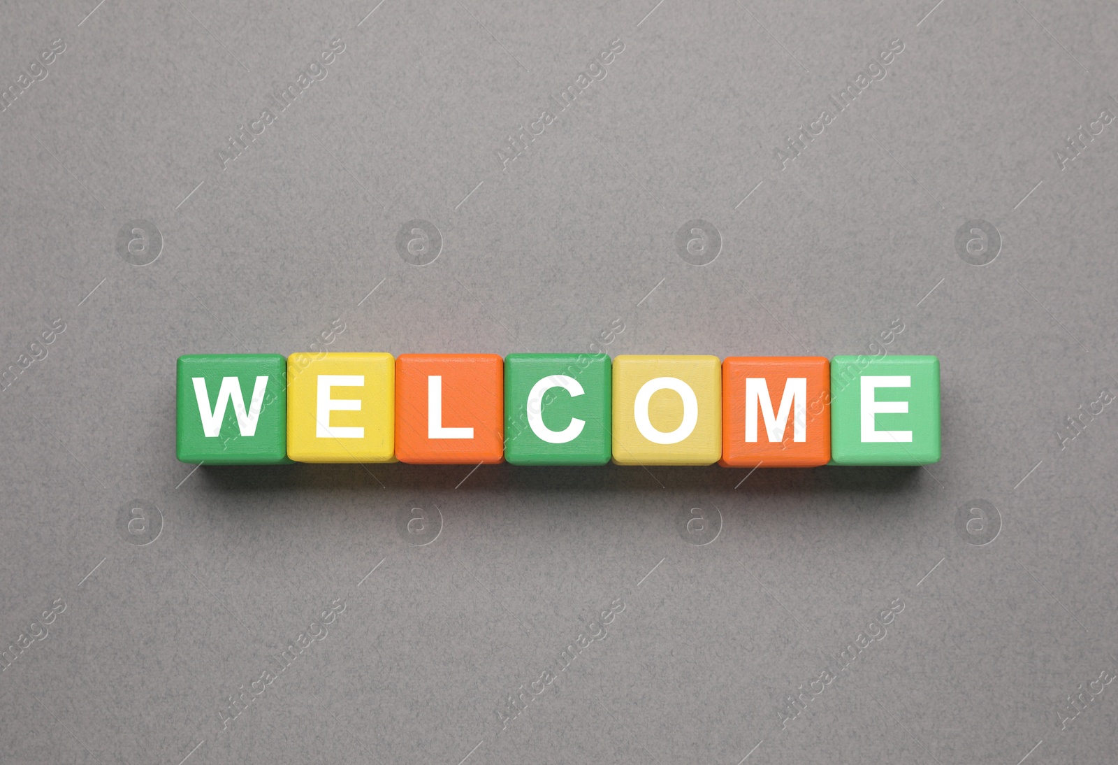 Word Welcome made of colorful cubes on grey background, top view Image of Word Welcome made of colorful cubes on grey background, top view