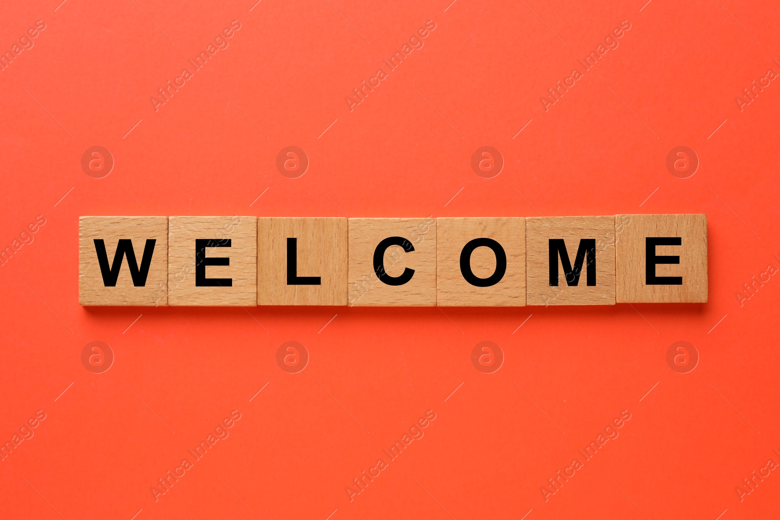 Word Welcome made of wooden cubes on red background, top view Image of Word Welcome made of wooden cubes on red background, top view