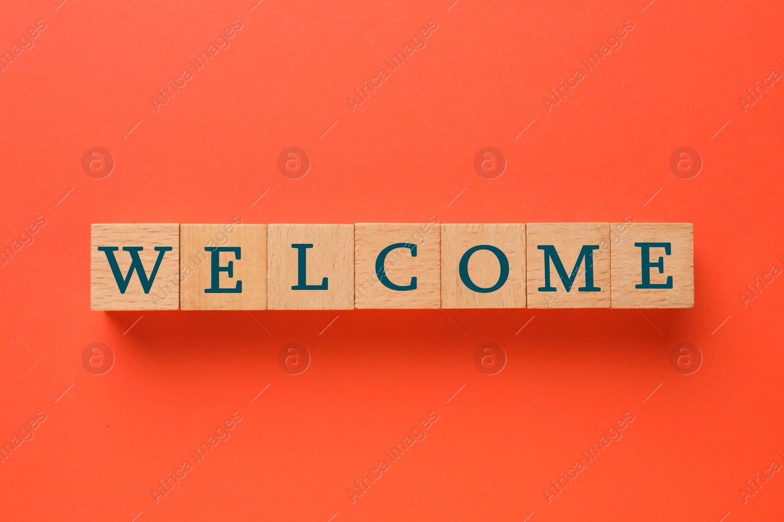 Word Welcome made of wooden cubes on red background, top view Image of Word Welcome made of wooden cubes on red background, top view