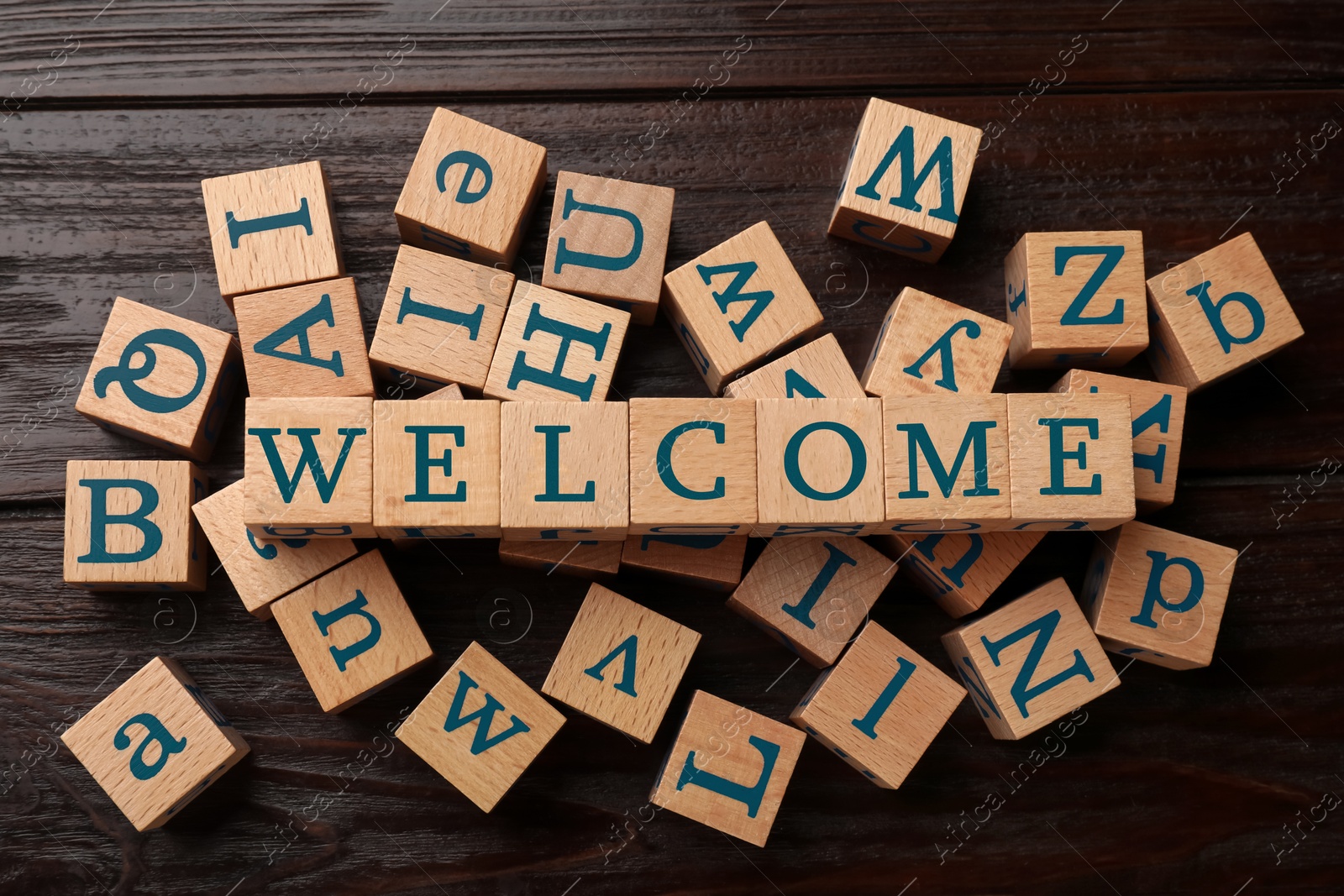 Word Welcome made of wooden cubes on table, top view Image of Word Welcome made of wooden cubes on table, top view