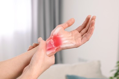 Image of Arthritis. Woman suffering from wrist pain indoors, closeup. Illustration of joint inflammation on her hand