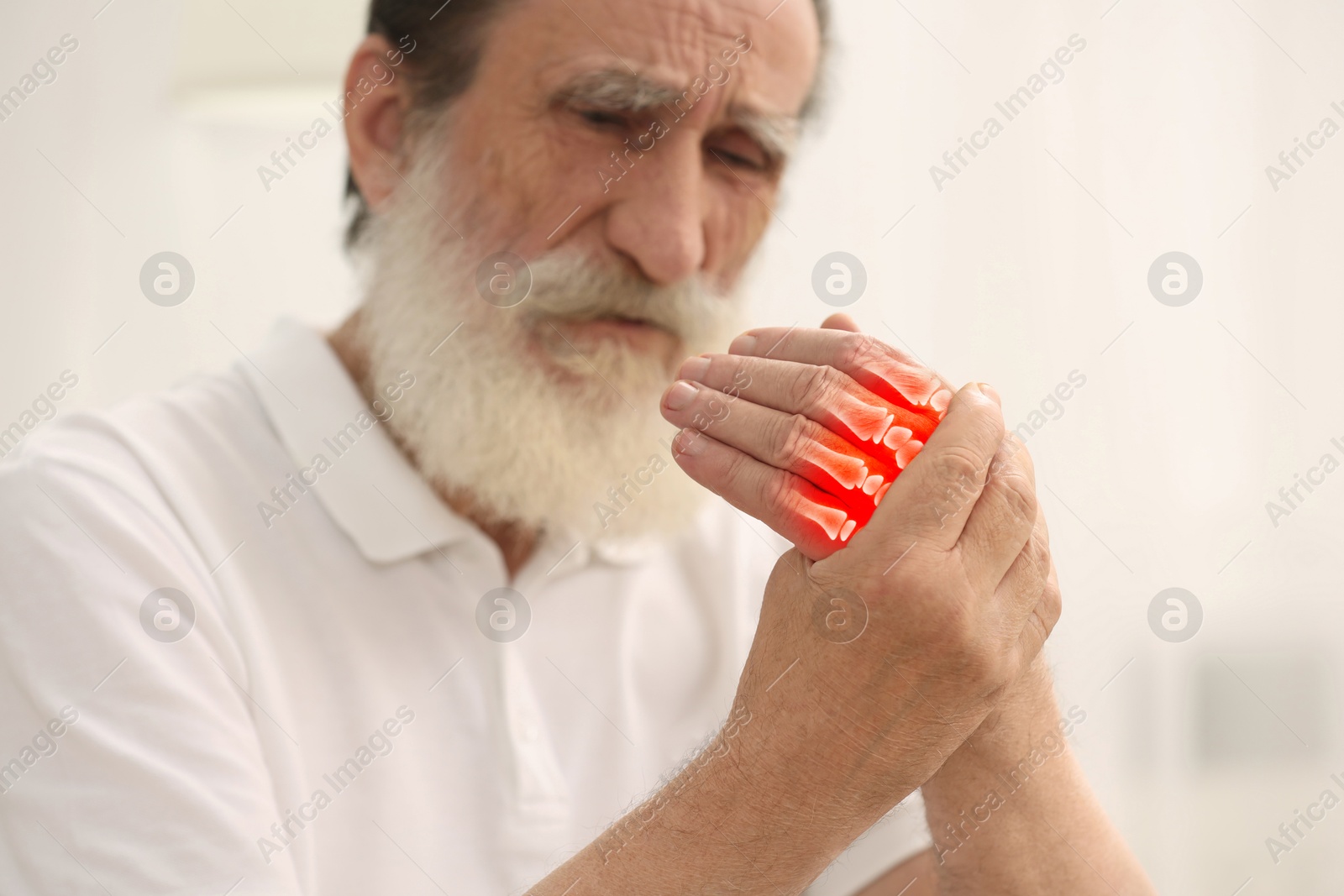 Image of Arthritis. Senior man suffering from pain in hand indoors, selective focus. Illustration of joint inflammation