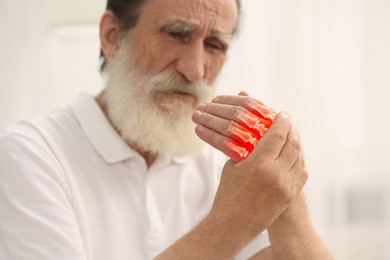 Image of Arthritis. Senior man suffering from pain in hand indoors, selective focus. Illustration of joint inflammation