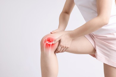 Image of Arthritis. Woman suffering from pain in knee on light background, closeup. Illustration of joint inflammation on her leg