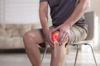 Image of Arthritis. Man suffering from knee pain indoors, closeup. Illustration of joint inflammation on his leg