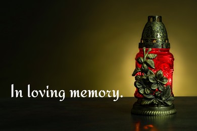 Image of In loving memory. Red grave light on table in darkness