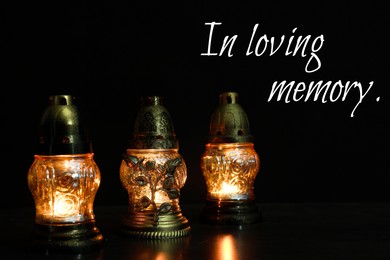 Image of In loving memory. Glowing grave lights on table in darkness