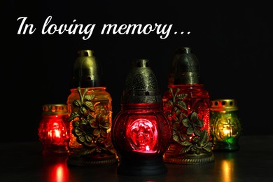 Image of In loving memory. Many glowing grave lights on table in darkness