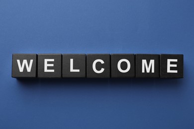 Image of Word Welcome made of black cubes on blue background, top view