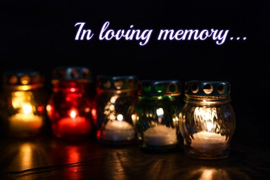 Image of In loving memory. Many grave lights on table in darkness