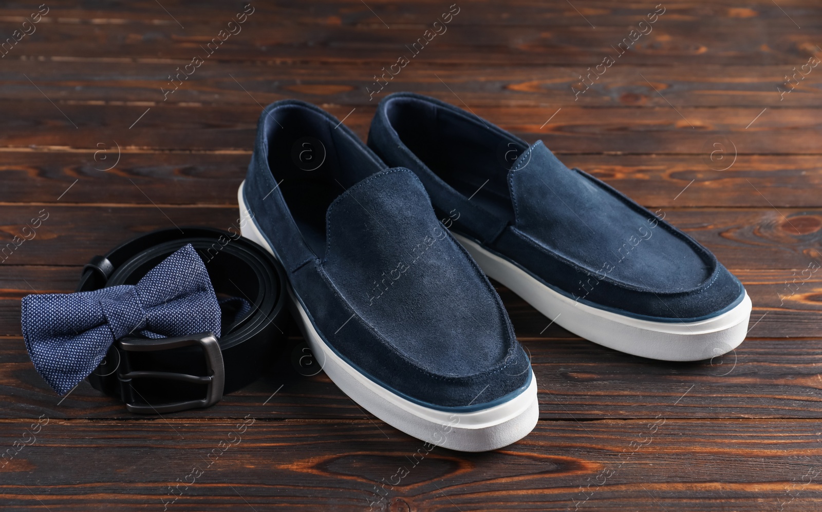 Pair of dark blue shoes, belt and bow tie on wooden surface, closeup Photo of Pair of dark blue shoes, belt and bow tie on wooden surface, closeup