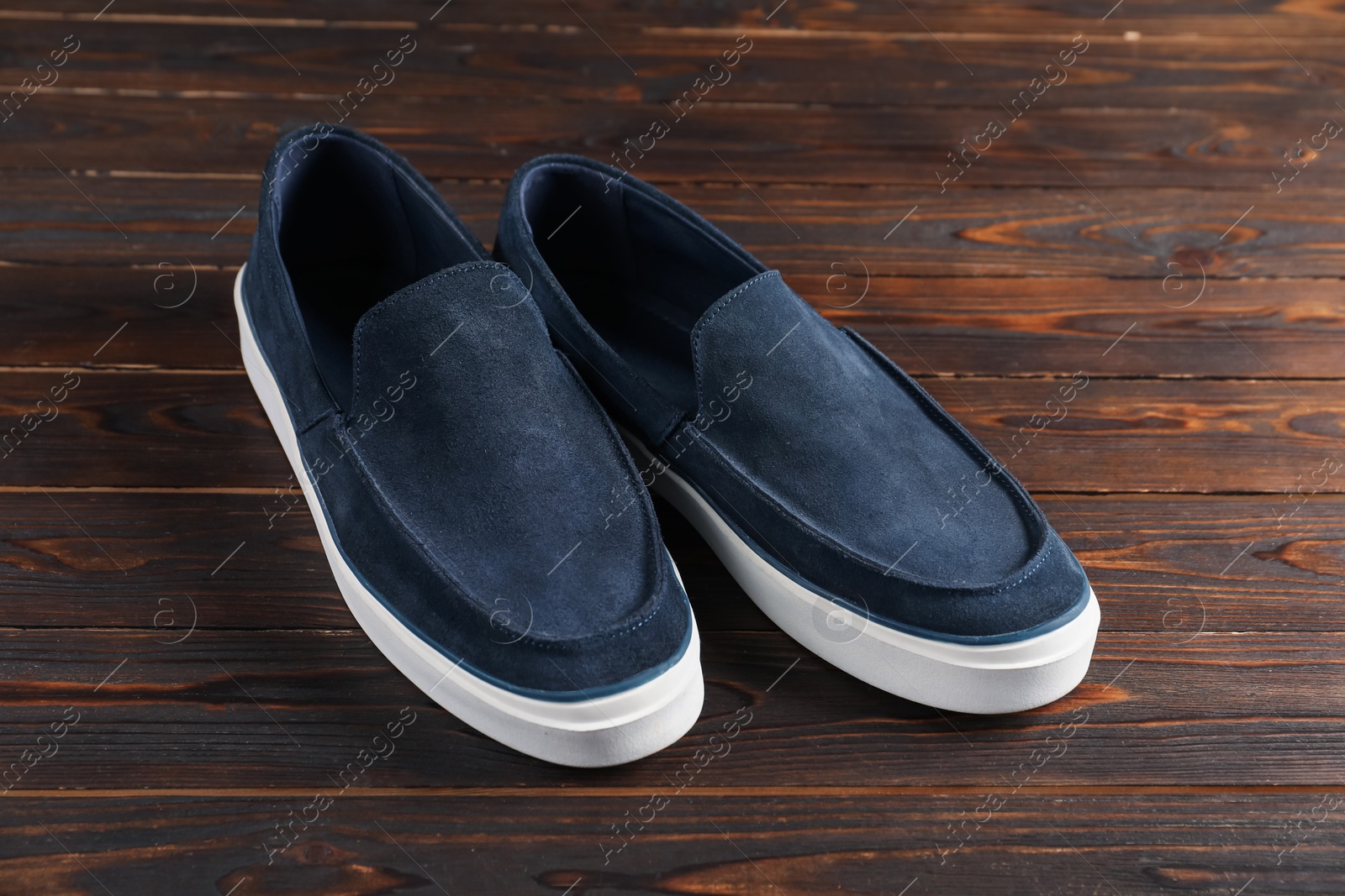 Photo of Pair of dark blue shoes on wooden surface
