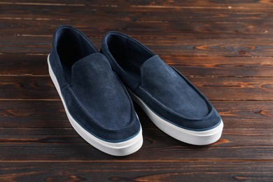 Photo of Pair of dark blue shoes on wooden surface