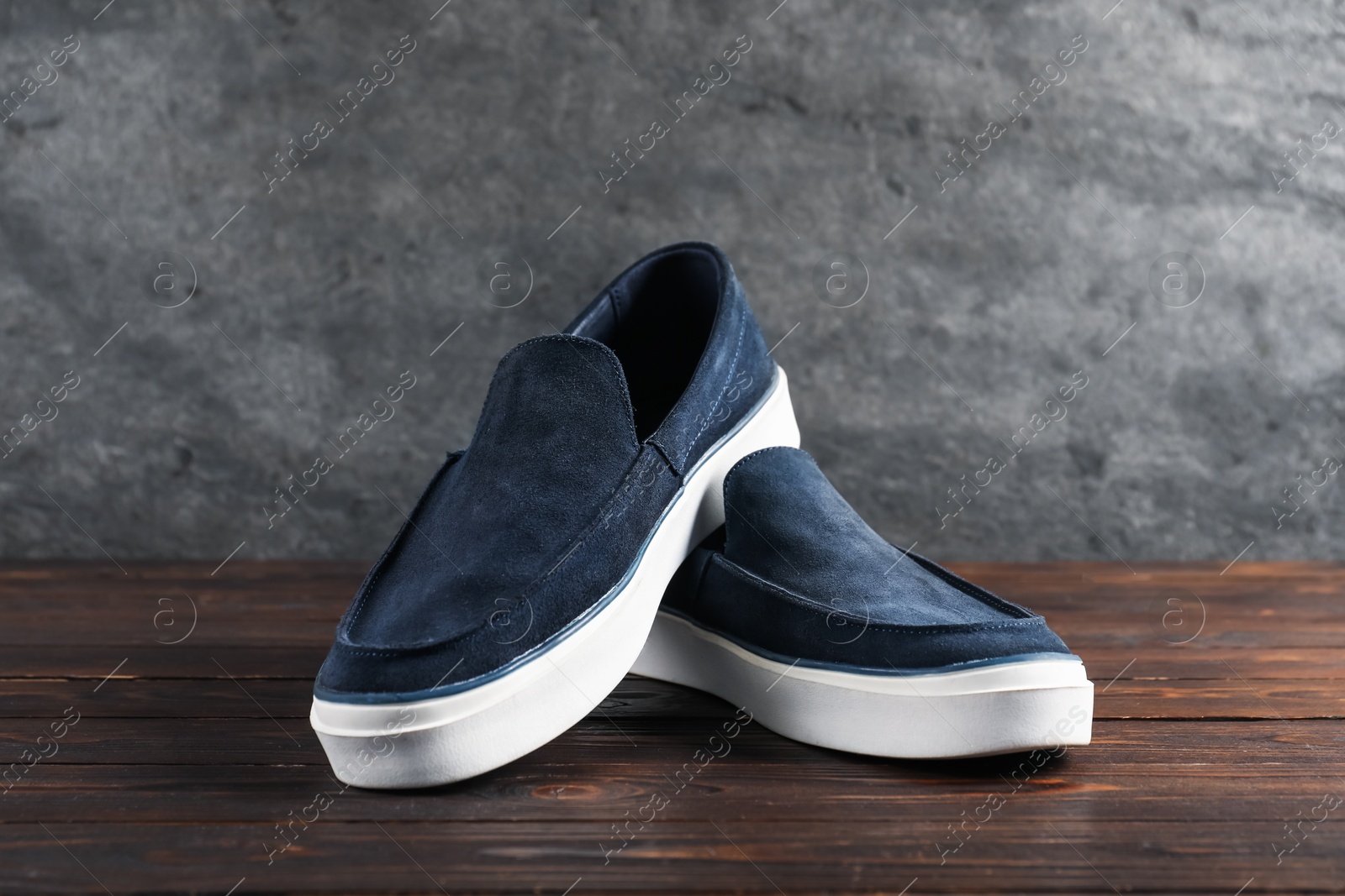 Photo of Pair of dark blue shoes on wooden surface