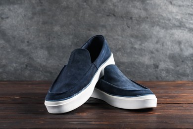Photo of Pair of dark blue shoes on wooden surface