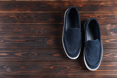 Photo of Pair of dark blue shoes on wooden surface, flat lay. Space for text