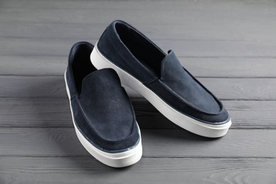 Photo of Pair of dark blue shoes on grey wooden surface, closeup