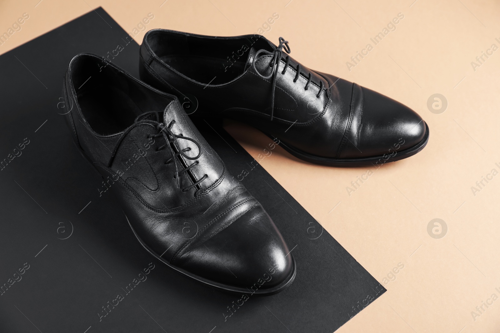 Photo of Pair of black leather shoes on color background, closeup