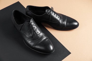 Photo of Pair of black leather shoes on color background, closeup