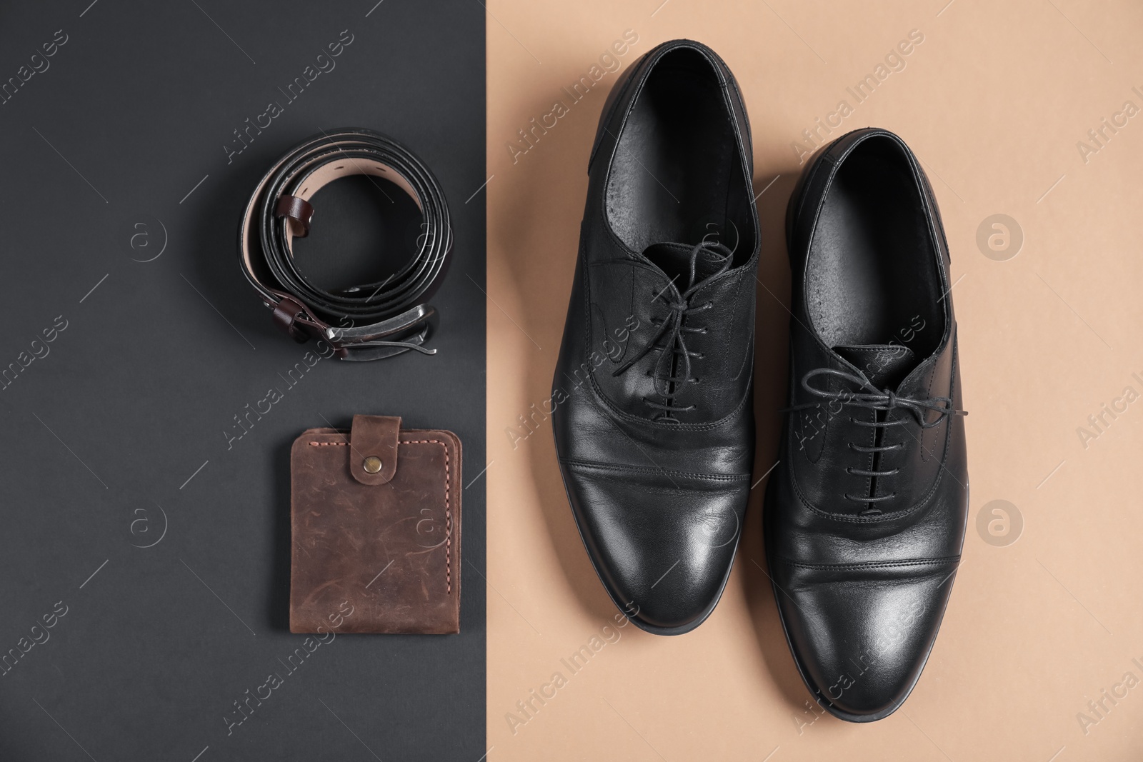 Photo of Pair of black leather shoes, purse and belt on color background, flat lay