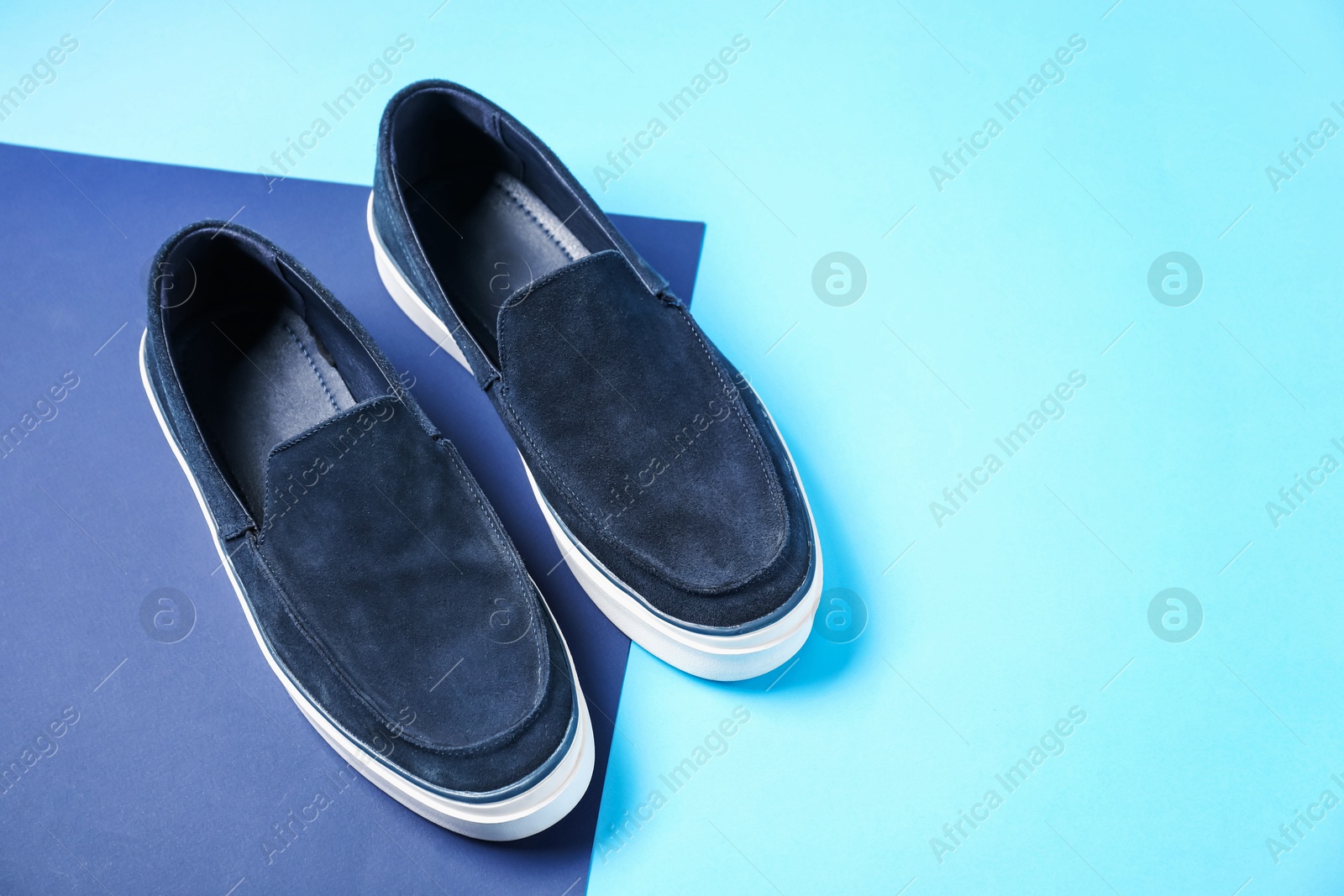 Photo of Pair of dark blue shoes on color background, above view. Space for text
