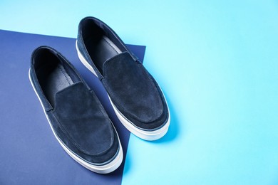 Photo of Pair of dark blue shoes on color background, above view. Space for text