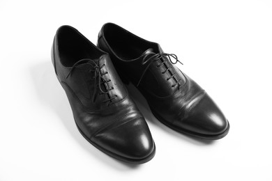 Photo of Pair of black leather shoes on white background